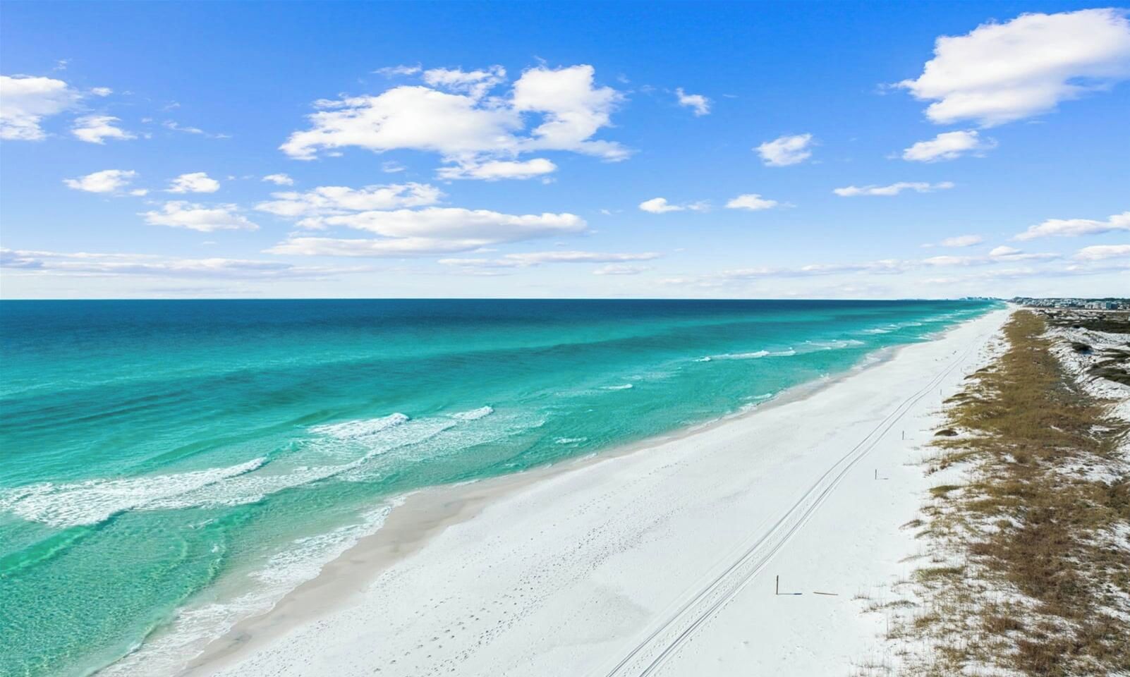 A beach with clear turquoise waters and a white sandy shore.