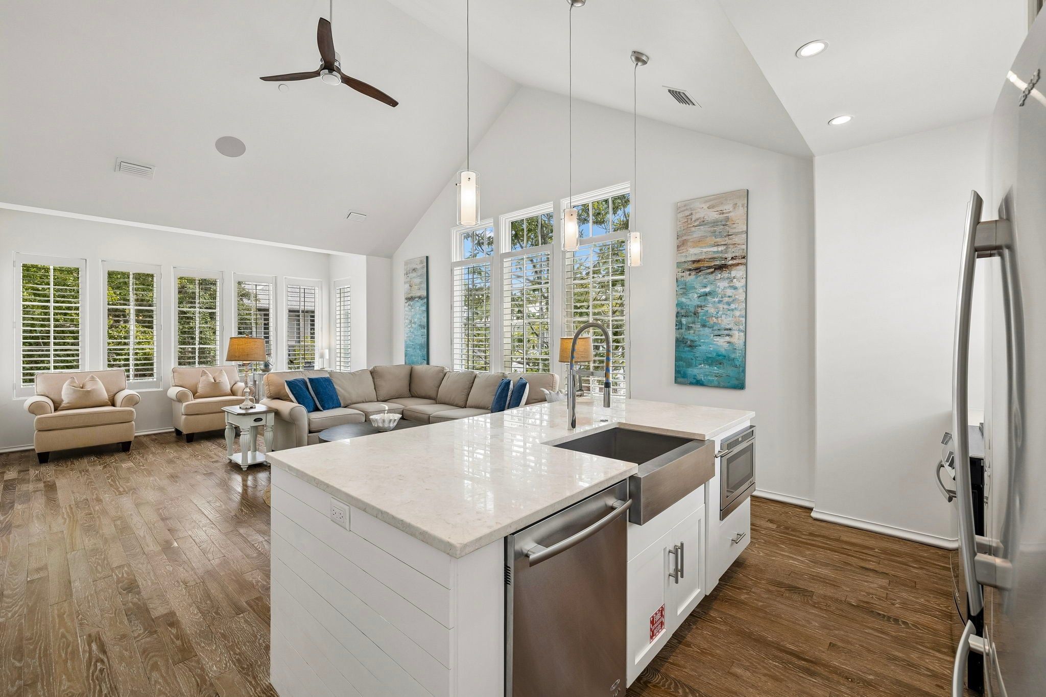 A spacious kitchen with a central island, modern appliances, and a dining area with a sofa.