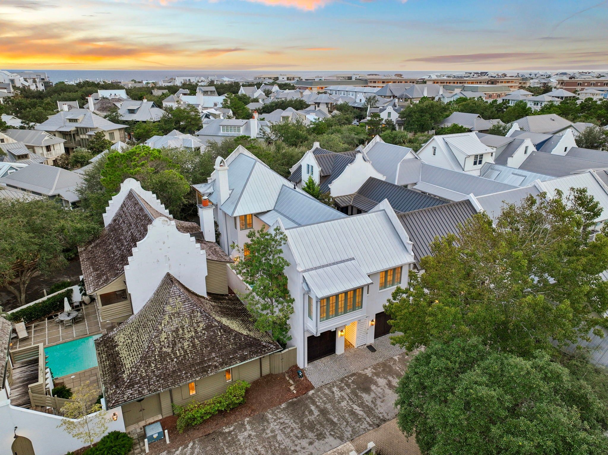 A residential area with houses featuring steep roofs and a swimming pool.