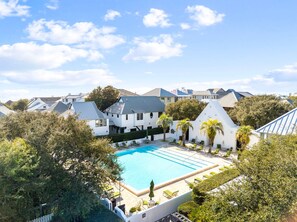 Ein Resort mit Swimmingpool, umgeben von weißen Gebäuden und Palmen.