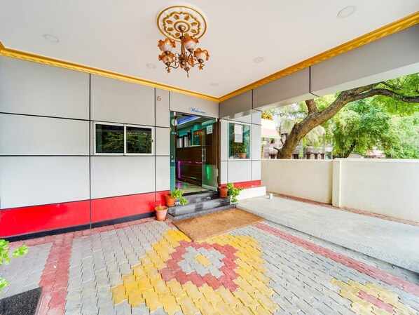 Una entrada de edificio con suelo de baldosas, un letrero de bienvenida y un candelabro.
