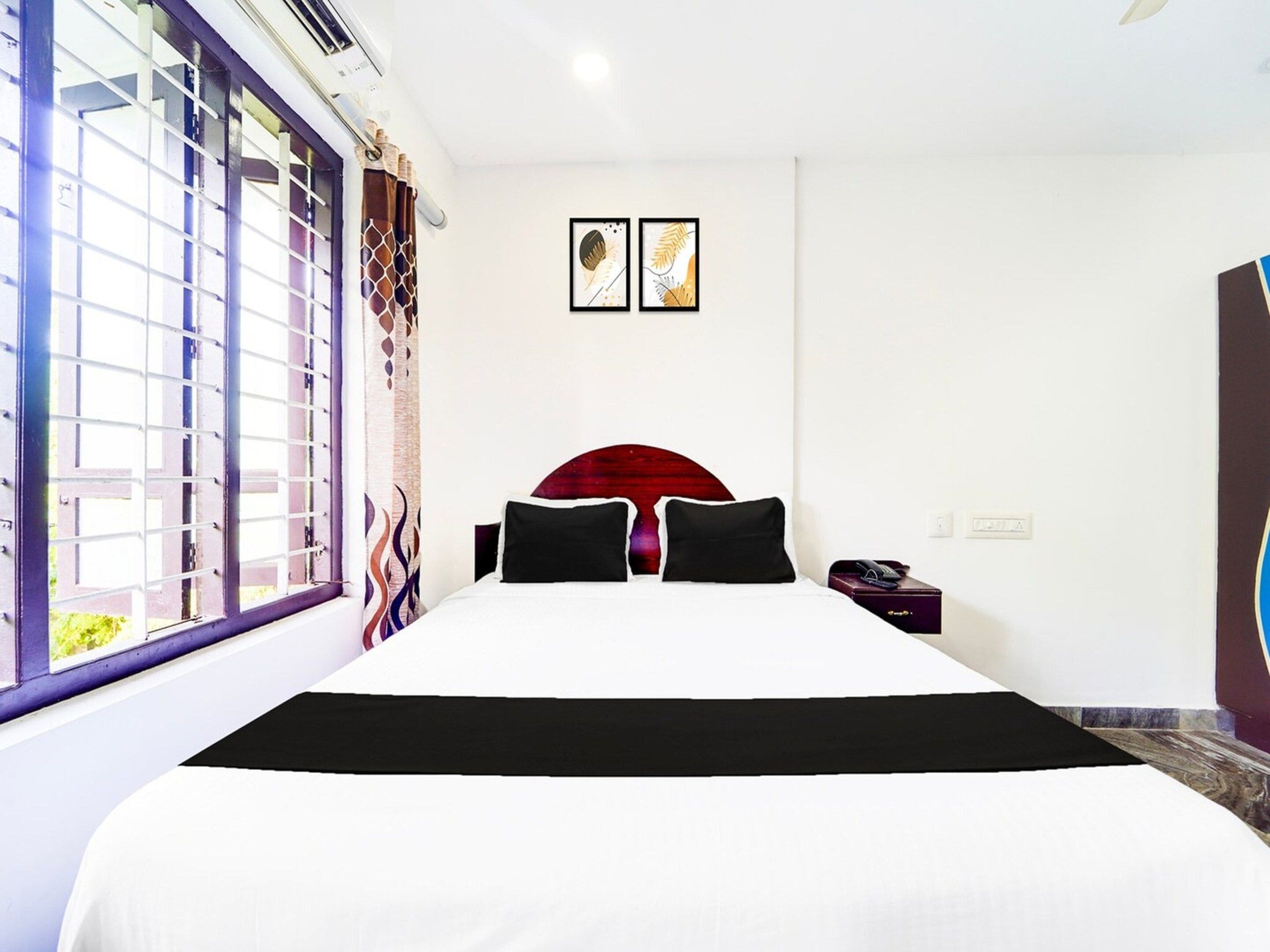 Una habitación de hotel con una cama grande, una ventana con vistas y una obra de arte colgada en la pared.