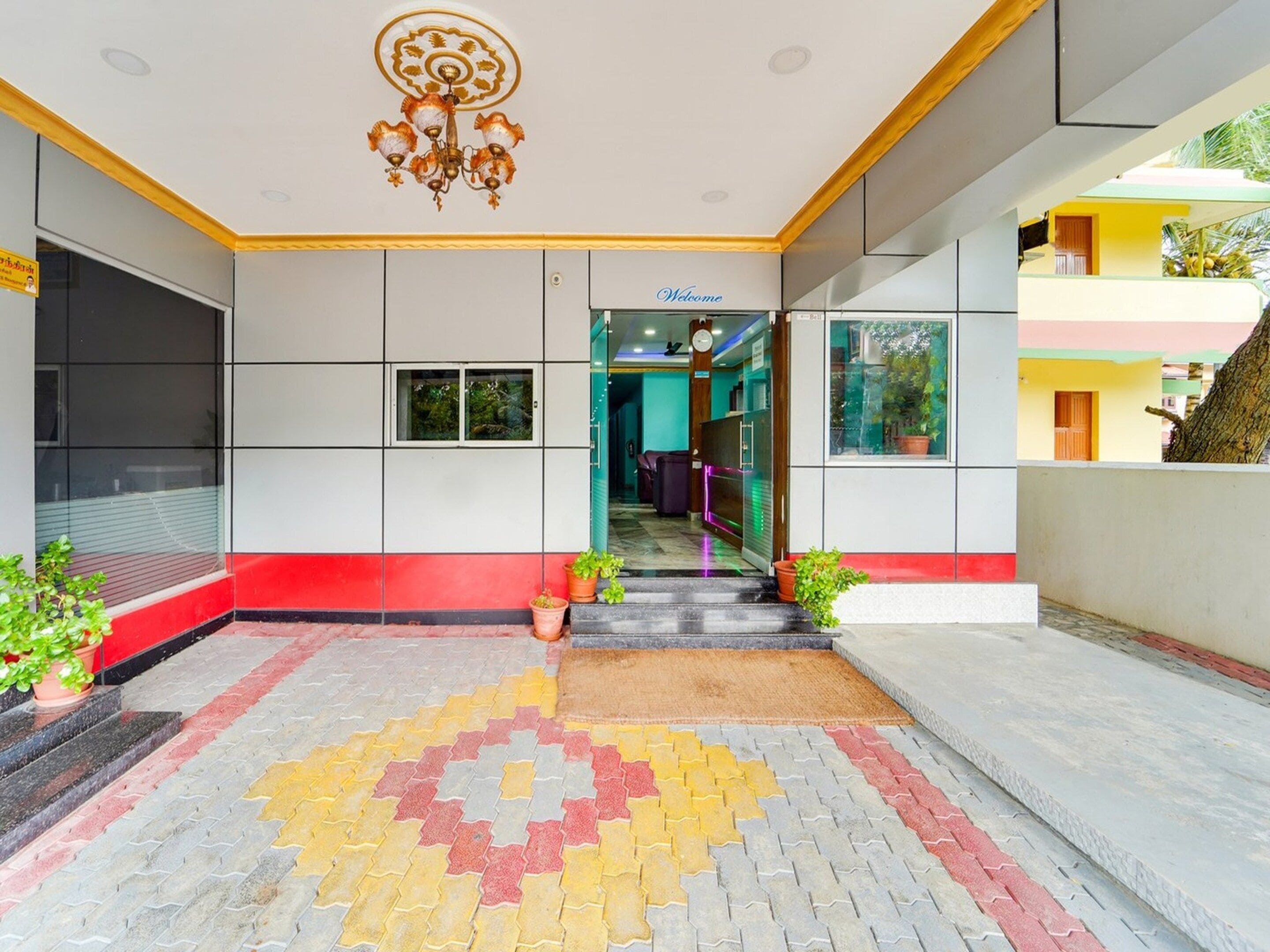 A hotel lobby with a patterned floor, a chandelier, and a 'Welcome' sign.