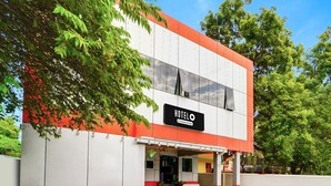 Um hotel com fachada moderna, uma placa de identificação e uma área de entrada coberta.