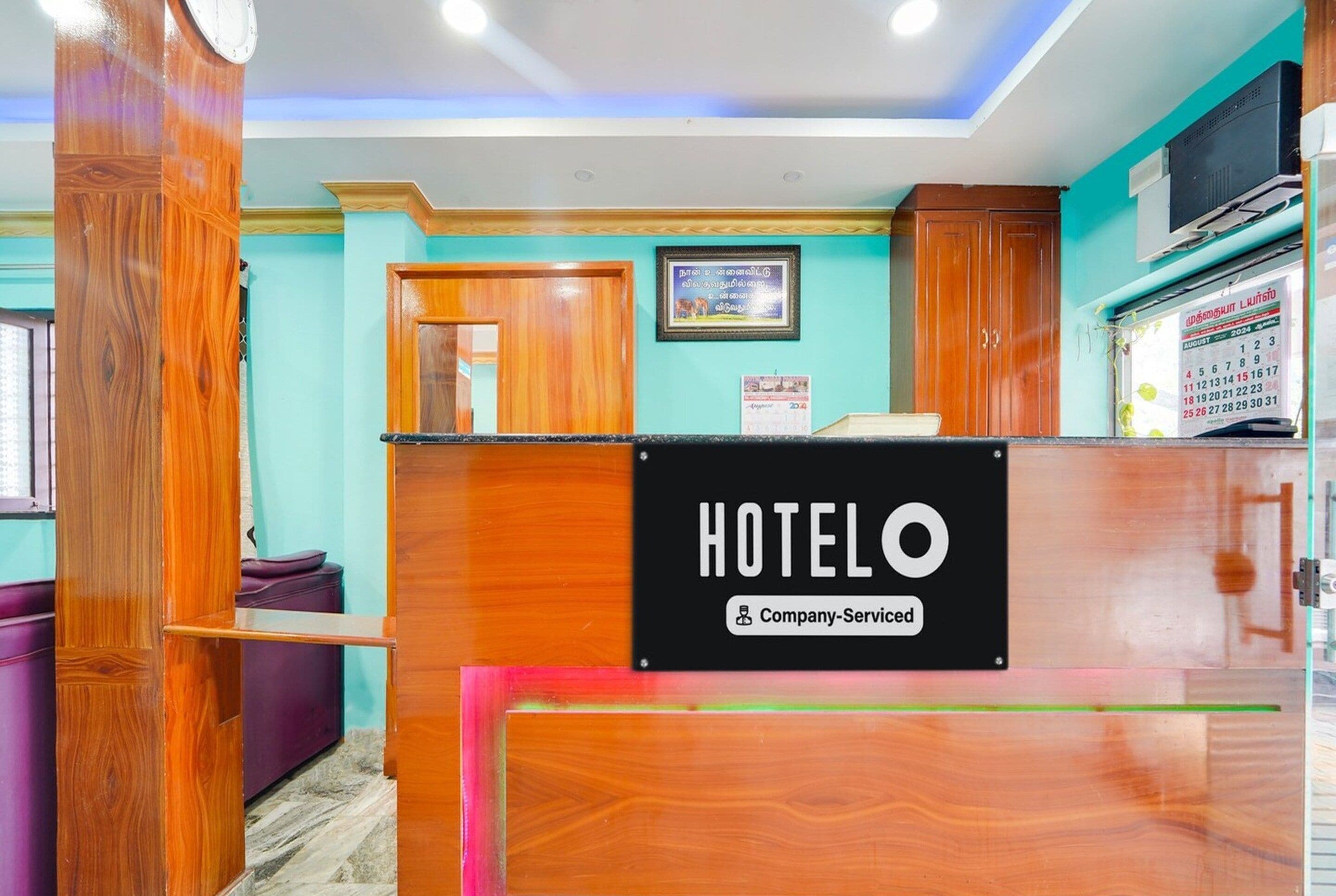 A hotel reception desk with a sign that reads "HOTELO Company-Serviced".