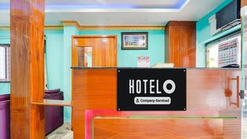A hotel reception desk with a sign that reads "HOTELO Company-Serviced".