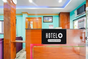 A hotel reception desk with a sign that reads "HOTELO Company-Serviced".