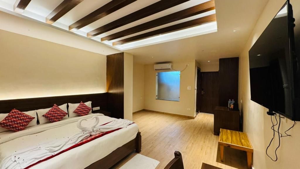 A modern hotel room with a bed, a TV, a wooden floor, and a skylight.