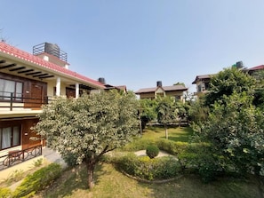 Un patio con varios edificios, un jardín central y cielo despejado.