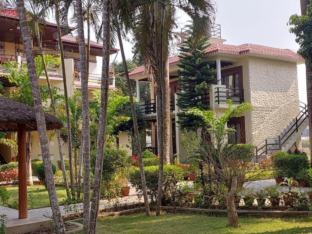 A resort with multiple buildings, outdoor seating areas, and lush greenery.
