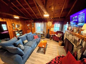 Ein gemütliches Wohnzimmer mit einem blauen Sofa, einem Holztisch und einem Kamin.