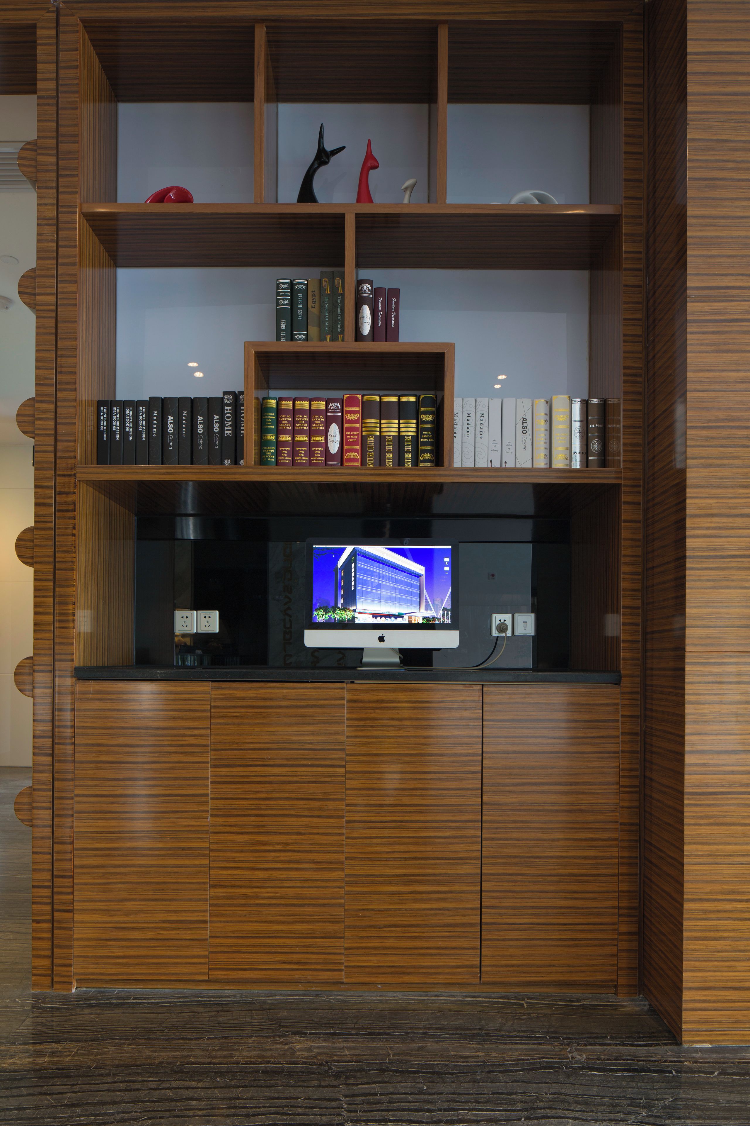 A wooden bookshelf with multiple shelves containing books and a television.