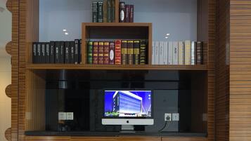 A wooden bookshelf with multiple shelves containing books and a television.
