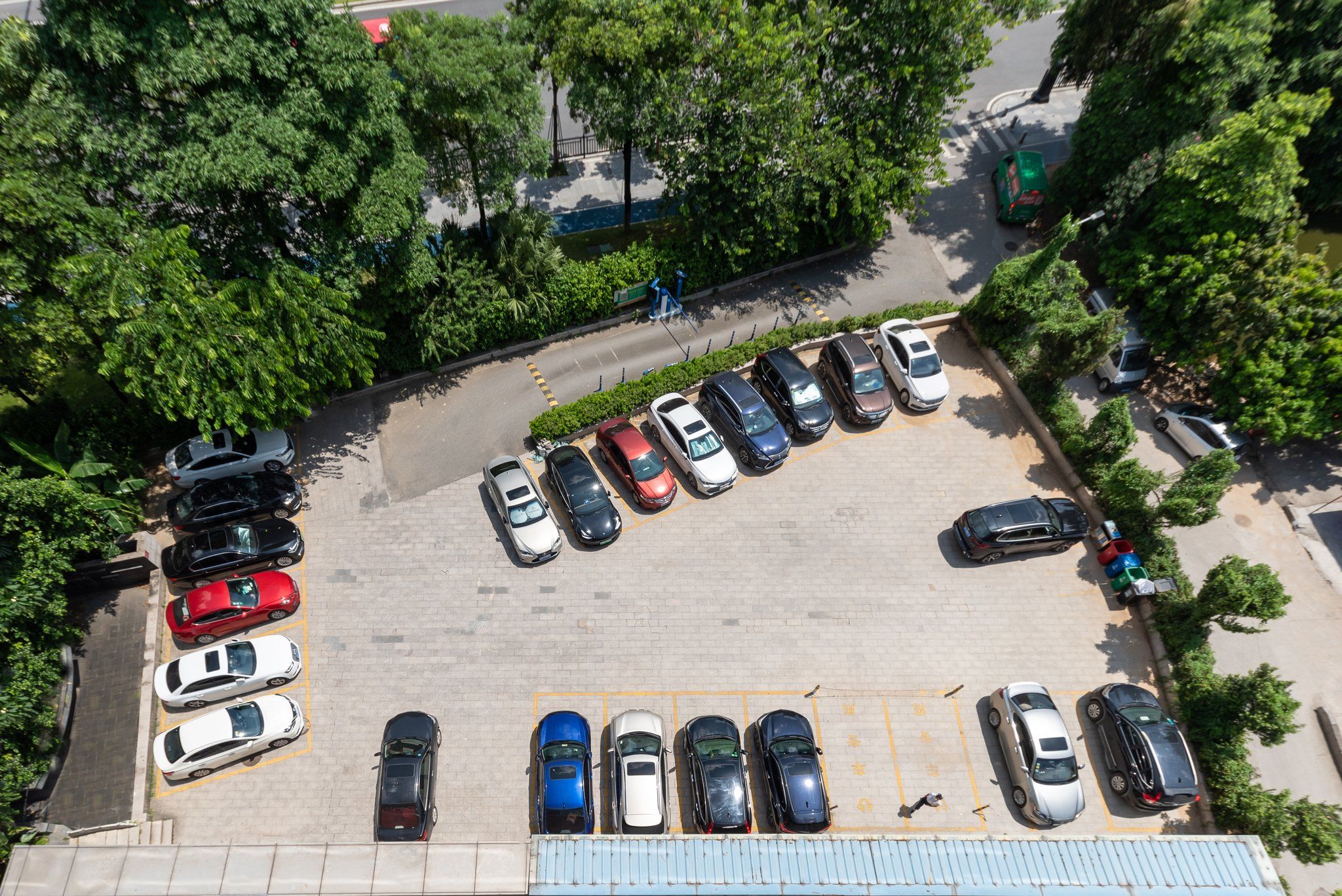 Vista aérea de um estacionamento com várias fileiras de carros estacionados.