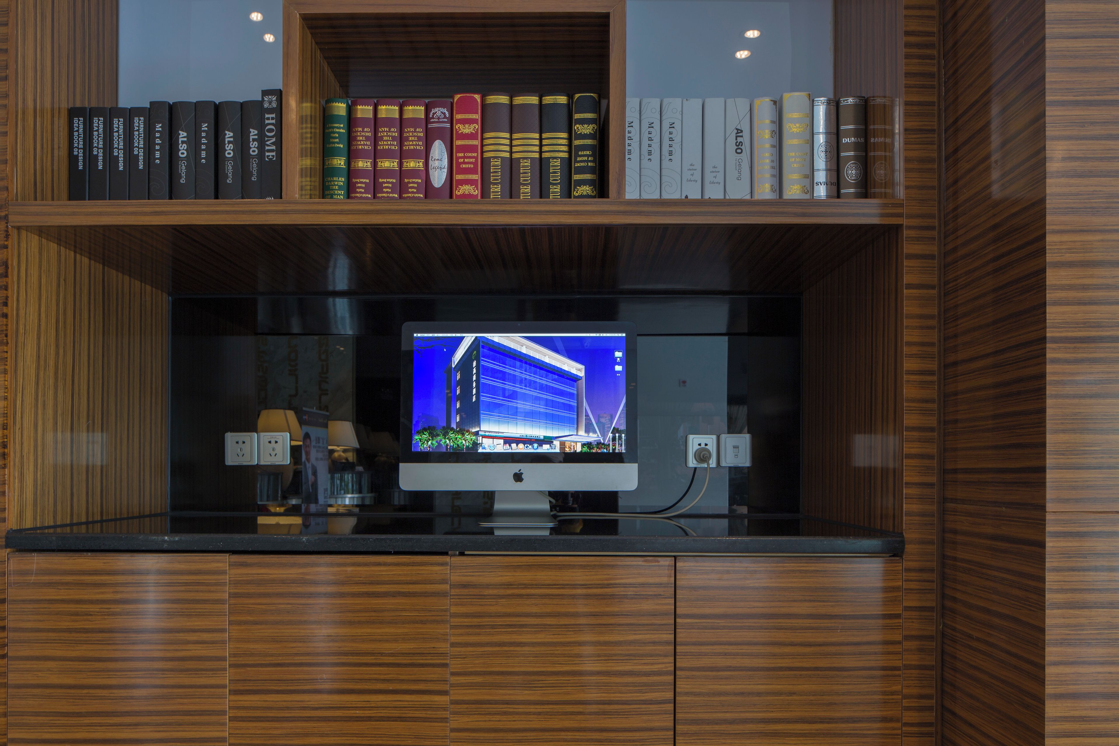 Una libreria in legno con libri e un televisore a schermo piatto.