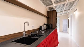 A modern kitchen with a stainless steel sink, a gas stove, and a red countertop.