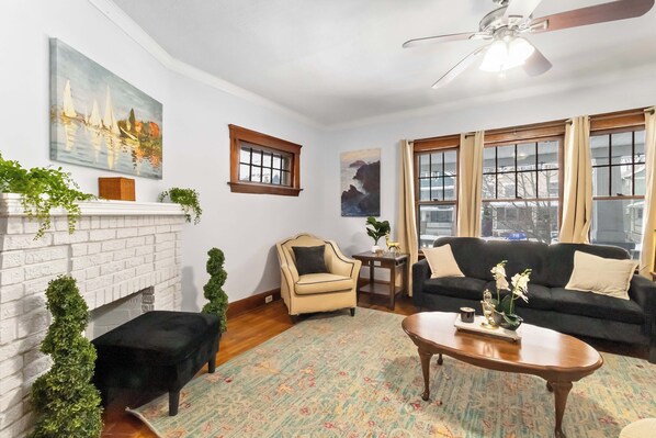 A living room with a fireplace, two sofas, a coffee table, and a ceiling fan. - Extremely walkable Lakewood, Central location (Lakewood)