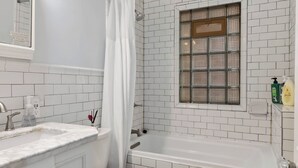 Ein Badezimmer mit einer weißen Badewanne, einer Toilette und einer Duschvorhang.
