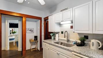 A modern kitchen with white cabinets, a granite countertop, and stainless steel appliances.