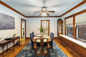 A dining area with a ceiling fan, a large window with blinds, and a view of the outside. - Lakewood Park Main Floor, Free parking (Lakewood)