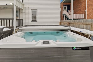 A hot tub with a wooden exterior, a white roof, and a window. - Lakewood Park Main Floor, Free parking (Lakewood)