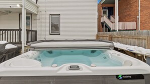 Ein Whirlpool mit Holzverkleidung, einem weißen Dach und einem Fenster.