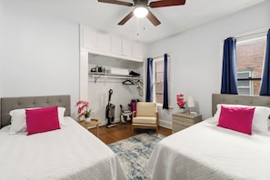 A hotel room with two beds, a ceiling fan, a window with curtains, a chair, a small table, and a closet. - Extremely walkable Lakewood, Central location (Lakewood)