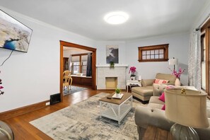 A living room with a fireplace, a sofa, a coffee table, and a TV mounted on the wall. - Lakewood Park 2nd Floor, Free parking (Lakewood)