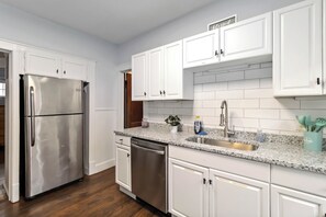 A modern kitchen with white cabinetry, stainless steel appliances, a granite countertop, and a built-in sink. - Lakewood Park 2nd Floor, Free parking (Lakewood)