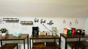 Ett café med bord, stolar, utrustning för att göra kaffe och dekorationer på väggarna.