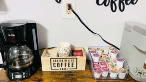 En kaffebryggare, en låda märkt med texten ”Homebrew & Co. Coffee House” och en behållare med kaffekoppar.