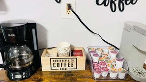 Een koffiezetapparaat, een doos met de tekst 'Homebrew & Co. Coffee House' en een houder met koffiekopjes.