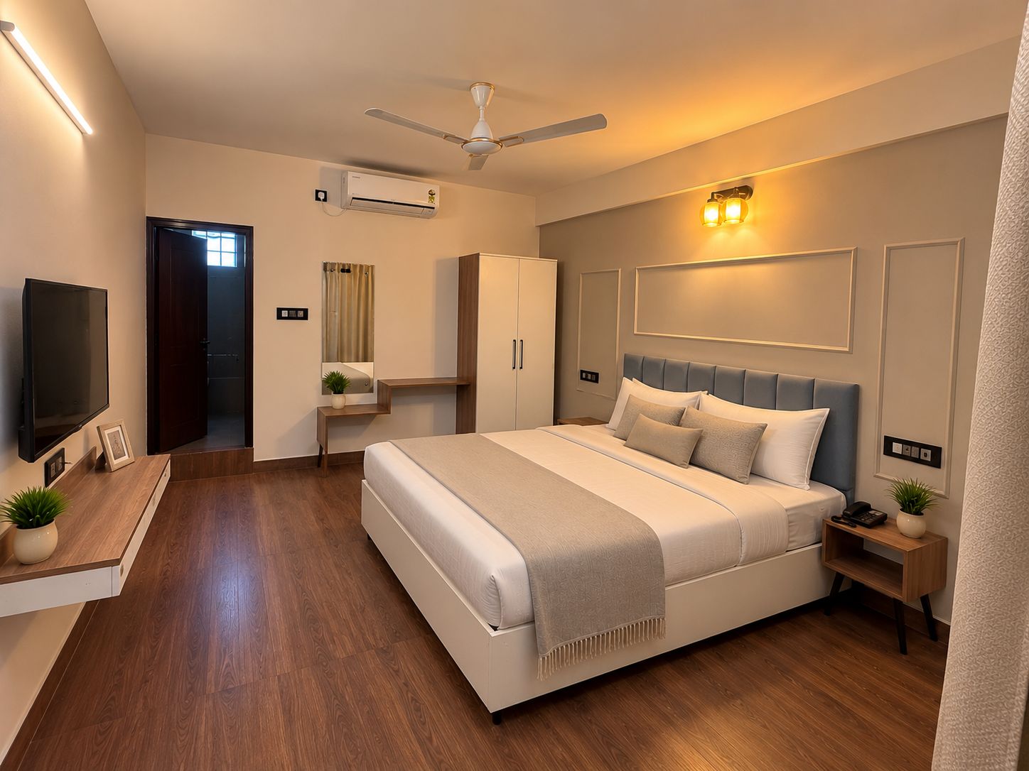 A modern bedroom with a large bed, bedside tables, a TV, and a ceiling fan.