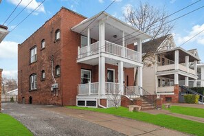 A two-story brick building with a white balcony and a covered porch. - ✨ Family-Friendly Charm in the Heart of Lakewood 🌿<br>Steps from Parks, Trails & Lake Views<br>Welcome to your serene escape in Lakewood—where convenience meets charm in one of Cleveland’s most walkable neighborhoods. (Lakewood)