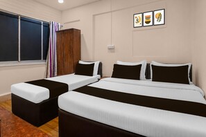A hotel room with two single beds and a double bed, a wardrobe, a window with curtains, and three framed artworks on the wall. - Classic Santacruz Metro Station (Mumbai)