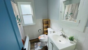 Ein Badezimmer mit Toilette, Waschbecken und einer Holzregaleinrichtung.
