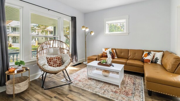 Ein Wohnzimmer mit Sofa, Sessel, Couchtisch und Stehlampe.