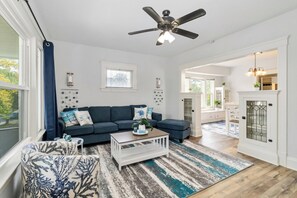 A living room with a sectional sofa, a coffee table, and a patterned rug. - Your Coastal Getaway in West Cleveland! (Cleveland)