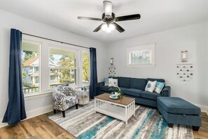 A living room with a sofa, coffee table, and a ceiling fan. - Your Coastal Getaway in West Cleveland! (Cleveland)