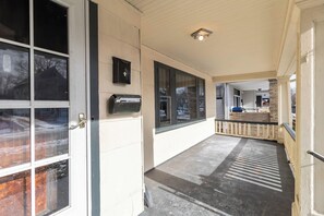 A covered porch with a mailbox, a wall-mounted light fixture, and a view into the house. - Single Family house Close to Freeway for easy access to everywhere in Cleveland! (Cleveland)