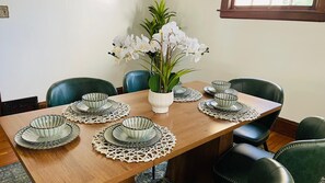 A dining table set with plates, bowls, and a vase of flowers. - Single Family house Close to Freeway for easy access to everywhere in Cleveland! (Cleveland)