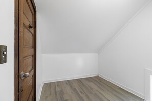 A room with a wooden door, white walls, and a wooden floor. - Single Family house Close to Freeway for easy access to everywhere in Cleveland! (Cleveland)