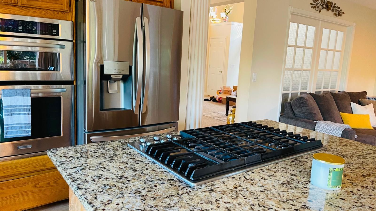 A kitchen with a stainless steel refrigerator, a built-in oven, a water dispenser, and a gas stove.