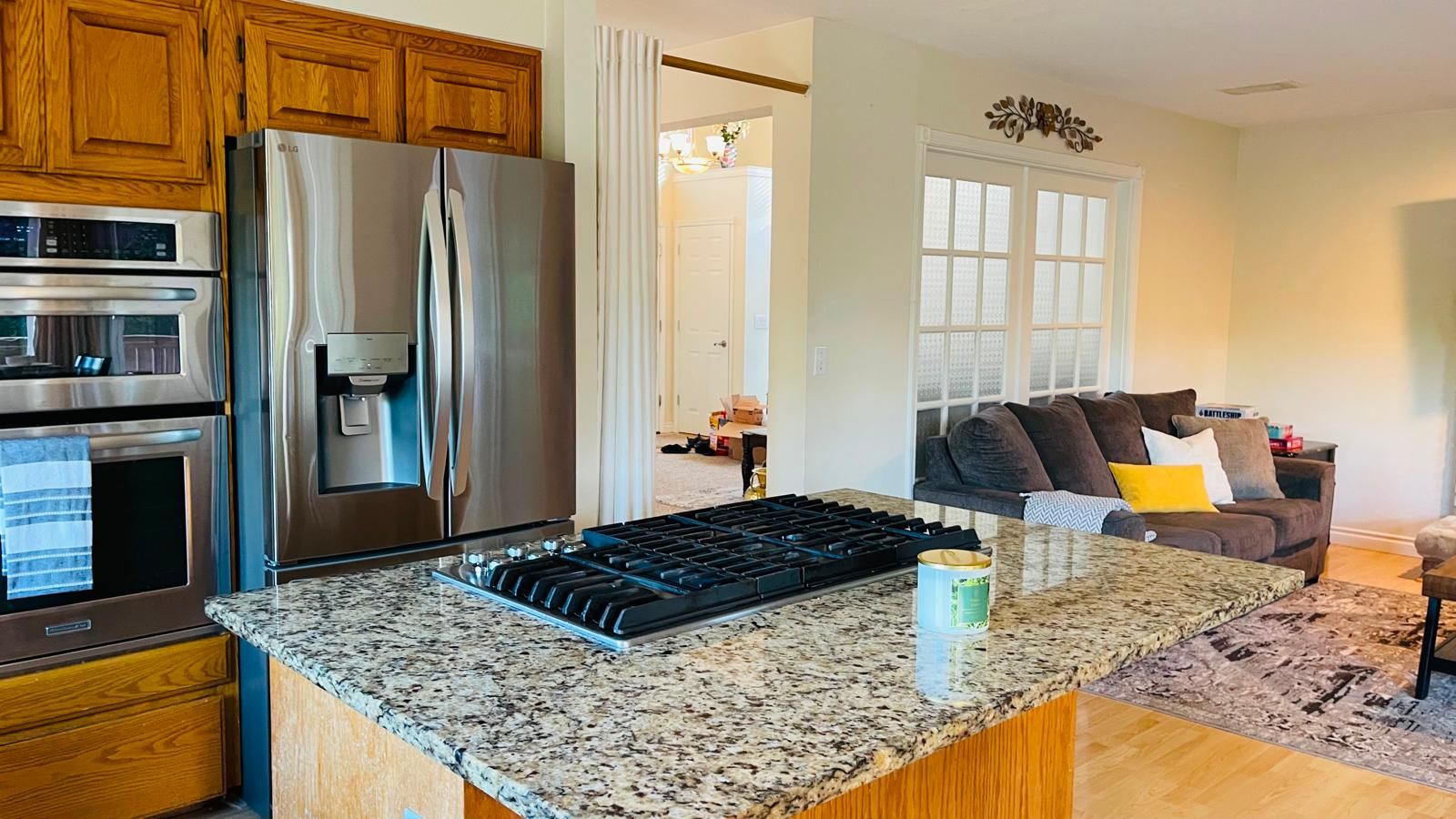 A kitchen with a stainless steel refrigerator, double oven, and a gas stove.