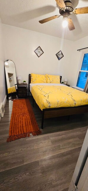 A bedroom with a bed, a ceiling fan, a mirror, and a window. - Recent  Remodeled UP Unit 3bedroom in West CLE (Cleveland)
