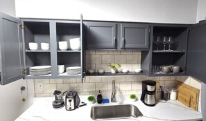 A kitchen with grey cabinets, a white countertop, a stainless steel sink, and various kitchen appliances. - Recent  Remodeled UP Unit 3bedroom in West CLE (Cleveland)