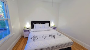 A bedroom with a bed, two bedside tables, a window, and a nightstand with a lamp. - Walkable to Lakewood & Rocky River  2nd floor (Lakewood)