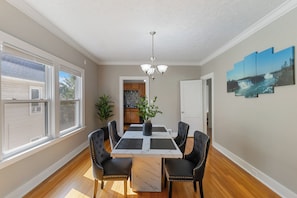 A dining area with a table, chairs, a chandelier, and a view of the outside. - Walkable to Lakewood & Rocky River  2nd floor (Lakewood)
