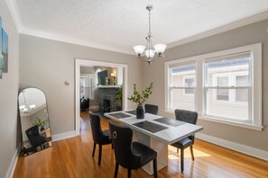 A dining area with a marble-top table, black upholstered chairs, and a hanging light fixture. - Walkable to Lakewood & Rocky River  2nd floor (Lakewood)