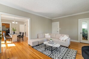 A living room with a sectional sofa, a coffee table, and a patterned rug. - Walkable to Lakewood & Rocky River  2nd floor (Lakewood)
